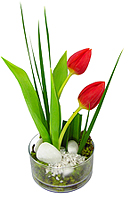 Tulipas em base de vidro adornada por folhagens e pedras marmorizadas.